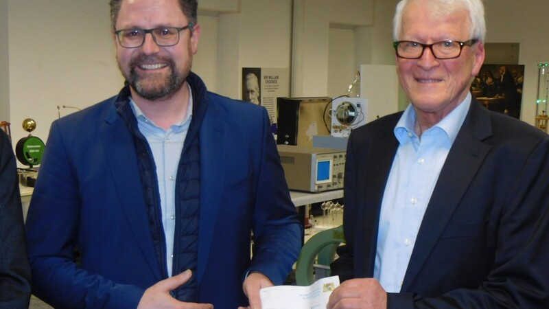 MdL Gerhard Hopp (links) überreicht Michael Heller den Förderbescheid aus dem bayerischen Wissenschaftsministerium.