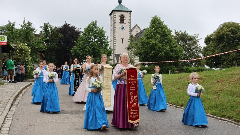 Stolz tragen die Festmädchen und die Festdamen ihre strahlend blauen Kleider beim Kirchenzug.