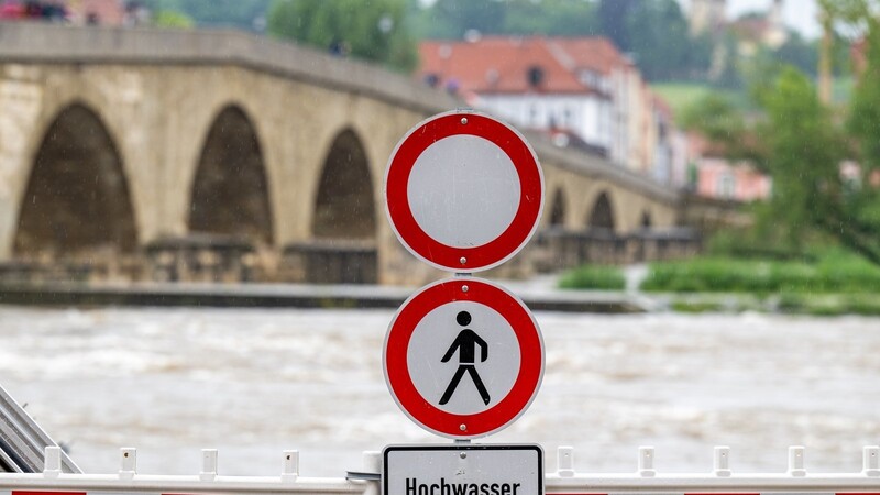 Ein Schild warnt an der Steinernen Brücke vor dem Hochwasser der Donau. Nach den ergiebigen Regenfällen der letzten Tage wird Hochwasser erwartet.