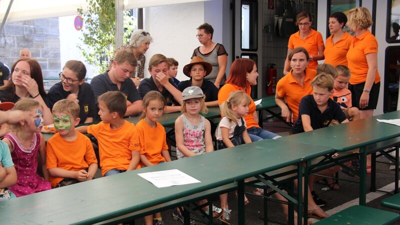 Diese Kinder könnten bald die jüngsten Schlatzendorfer Feuerwehrleute sein. Hinten stehend in orangen T-Shirts, auf denen am Rücken schon das Logo prangt, Erna Vogl (v.li.) und Carolin Wittmann.