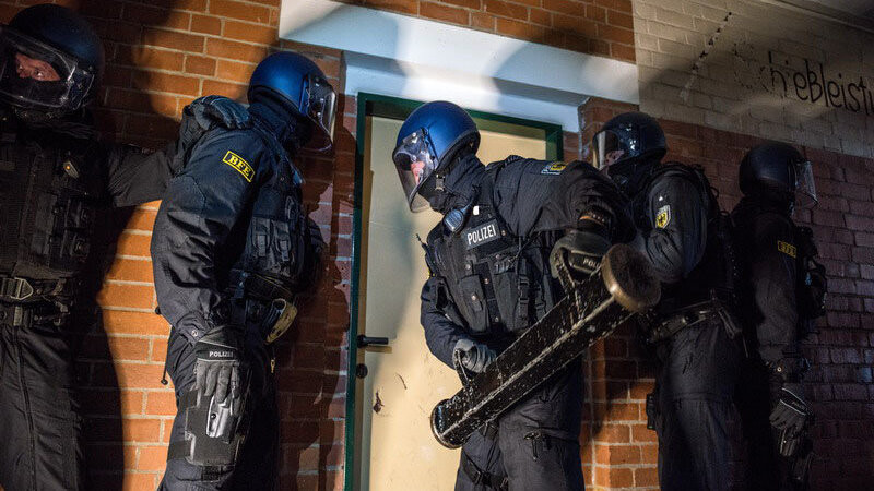 Beamten der Bundespolizei öffnen mit einer Ramme die Tür zur Wohnung eines Verdächtigen.(Symbolbild)