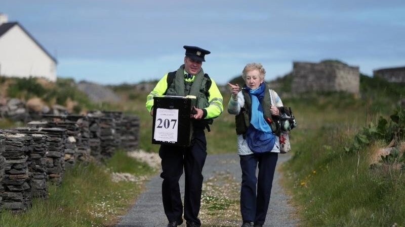 Carmel McBride (r) und Garda Adrian McGettigan tragen eine Wahlurne zu einem Wahllokal auf der Insel Inishbofin. Die Wähler auf der abgelegenen Insel vor der Küste von Donegal gehörten zu den ersten, die bei den Kommunal- und Europawahlen, einen Tag vor dem Rest des Landes, ihre Stimme abgeben.