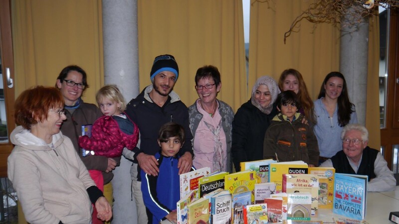 Die Mitarbeiter des ehrenamtlichen Helferkreises mit einer syrischen Familie sowie Büchereileiterin Nicole Geiger und Walter Müllner (re.).