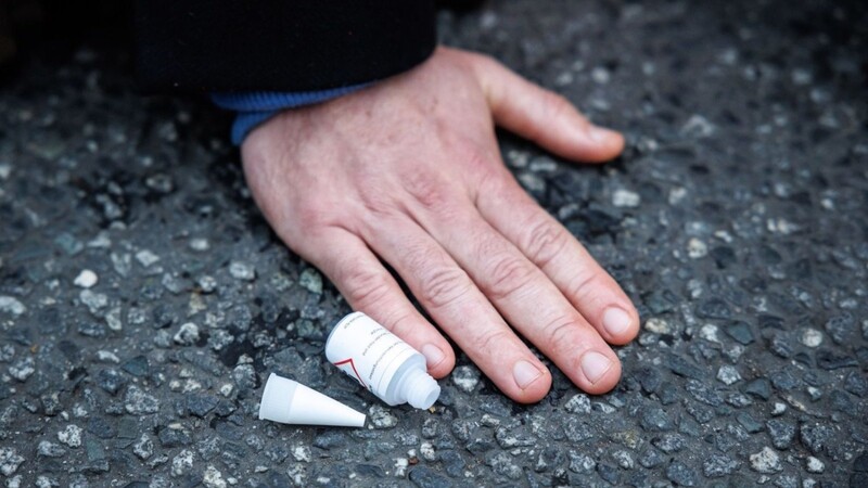 Ein Klimaaktivist hat sich mit der Hand auf einer Straße festgeklebt.