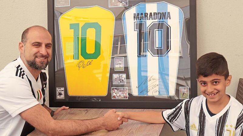Familienbande: Die beiden eingefleischten Juventus-Turin-Anhänger Domenico Infantino und Sohn Enes-Leandro sitzen vor den Trikots mit Original-Unterschriften von Pelé und Diego Armando Maradona. Es ist bereits beschlossene Sache, dass Enes-Leandro die im Wert steigenden Trikots eines Tages erben soll.