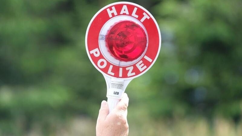 Eine Polizistin hält während einer Polizeikontrolle eine rote Winkerkelle in die Höhe. Foto: Sebastian Willnow/zb/dpa/Symbolbild