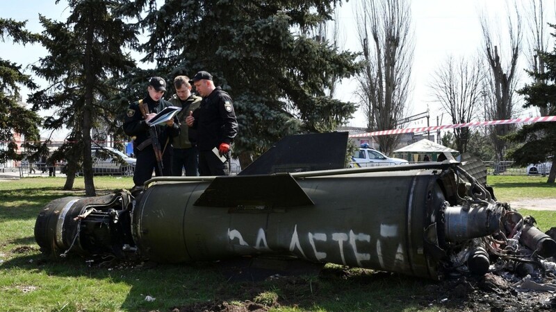 Ukrainische Soldaten während Ermittlungsarbeiten neben einem Fragment einer Tochka-U-Rakete mit der russischen Aufschrift "Für Kinder" nahe des Bahnhofs in Kramatorsk.