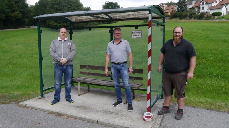 Der Vorsitzende der Verkehrswacht Gert Jablonski, Bürgermeister Heinz Niedermayer und Bauhofmitarbeiter Siegfried Wagner bei einem der Bushäuschen, die mit Reflektorbändern versehen werden.