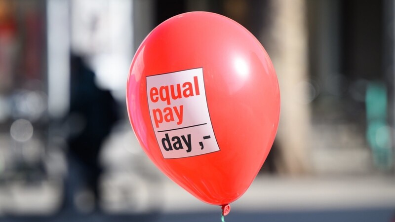 Ein Ballon mit Aufschrift "Equal Pay Day" fliegt in der Innenstadt.