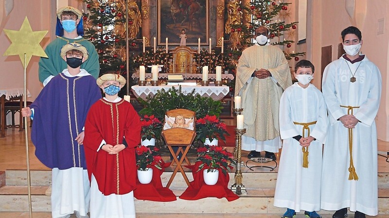 Sternsinger, Ministranten und Pater Robert Kennedy an den Stufen zum Altar.