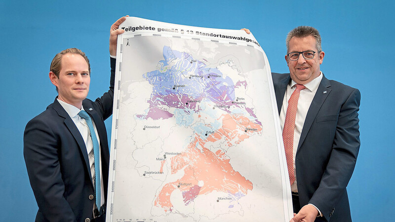 Stefan Studt (r.), Vorsitzender der Geschäftsführung der Bundesgesellschaft für Endlagerung (BGE), und Steffen Kanitz, Mitglied der Geschäftsführung der BGE, zeigen eine Landkarte mit Teilgebieten.