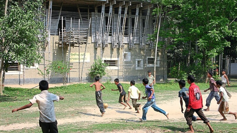 Pause bei METI - und auch an der Partnerschule des St.-Gotthard-Gymnasiums wird Fußball gespielt. Im Hintergrund das Schulgebäude aus Bambus und Lehm, dem traditionellen Baumaterial in Bangladesch.