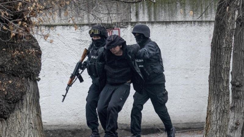 Schwer bewaffnete Polizisten nehmen einen Mann in Almaty fest, wo es erneut schwere Unruhen gegeben hat.