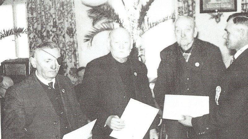 Fähnrich Josef Huber (l.) wurde beim Jubiläum im März 1964 vom damaligen Vorsitzenden Sebastian Scheuchenpflug (rechts) für seine 40-jährige Mitgliedschaft ausgezeichnet, die Gründungsmitglieder Franz Detterbeck (ab 2.v.l.) und Xaver Wittmann für ihre 60-jährige Vereinszugehörigkeit. Alle sind mittlerweile verstorben.