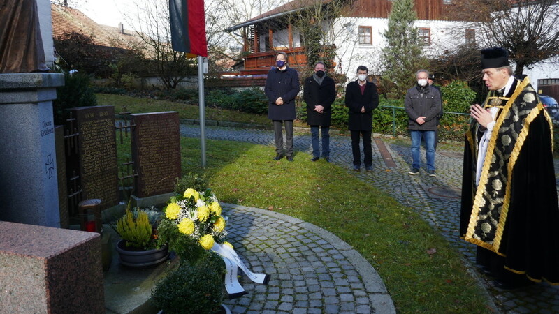 Nach der Gedenkfeier legte Bürgermeister Hans Luger (links) im Beisein von Pfarrer Franz Speckbacher und Mitgliedern des Gemeinderats am Kriegerdenkmal einen Kranz nieder.