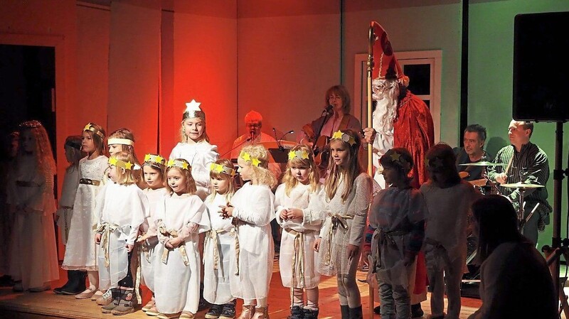 Eine große Schar Engel war dem Heiligen Nikolaus gefolgt, während Martin Göth und die Gruppe Shalom (im Hintergrund) die Lieder anstimmten und begleiteten.
