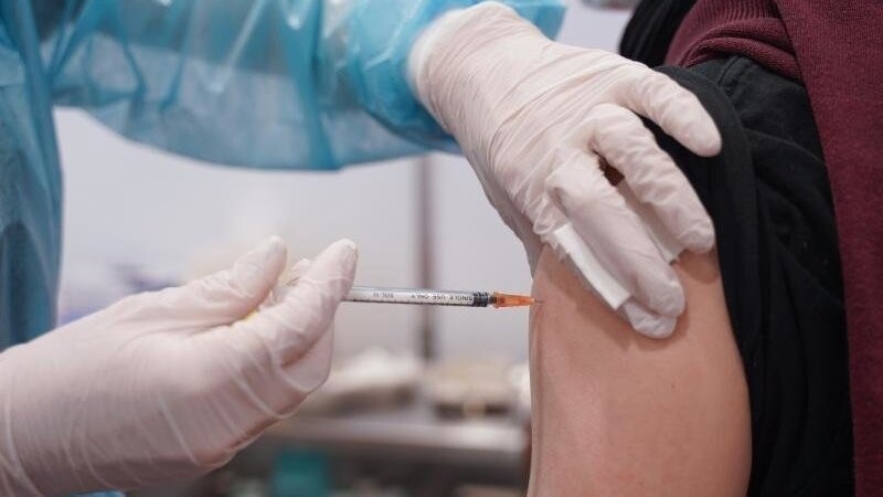 Ein junger Mann wird mit einer Booster-Dosis des Impfstoffs von Moderna geimpft. (Archivbild).