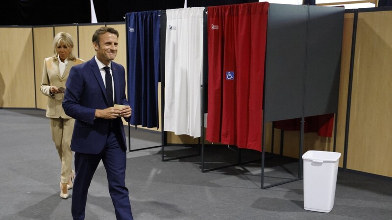 Emmanuel Macron, Präsident von Frankreich, und seine Frau Brigitte verlassen die Wahlkabine, bevor sie ihre Stimmen in der ersten Runde der französischen Parlamentswahl abgeben.
