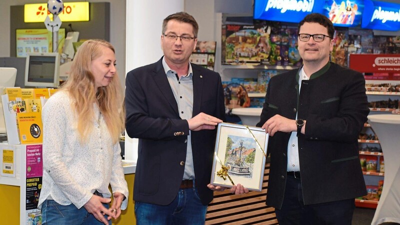 Bürgermeister Dr. Stefan Spindler übergibt ein Aquarell des Künstlers Siegfried W. Barz an Christian und Carina Weihrauch als Geschenk der Stadt Rötz zur Geschäftseröffnung.