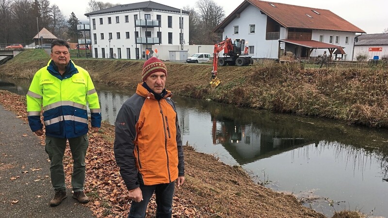 Bauaufseher Josef Stelzl (l.) und Helmut Holzer vom Wasserwirtschaftsamt Regensburg begutachten die Baustelle an der Hochwasserfreilegung. Im Hintergrund ist der Spezialbagger im Einsatz, der Sträucher und Gestrüpp schlegelt.