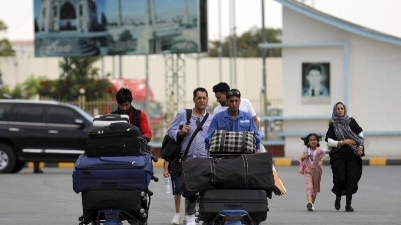 Passagiere gehen zum Abflugterminal des internationalen Flughafens Hamid Karzai in Kabul, Afghanistan, Samstag, 14. August 2021. Da die afghanische Hauptstadt von einer Taliban-Offensive umzingelt ist, gibt es für diejenigen, die vor dem Krieg fliehen, zunehmend nur noch einen Weg nach draußen.