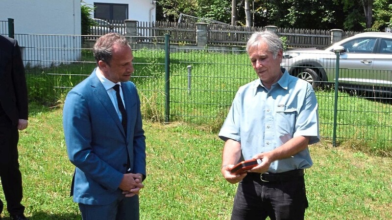 Stellvertretender Bürgervereins-Vorsitzender Wolfgang Herrmann zeigt dem Umweltminister Thorsten Glauber (l.) ein UFP-Messgerät.