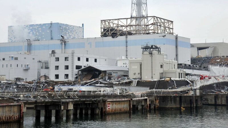 Die Ruinen des havarierten Atomkraftwerks Fukushima mit den Reaktoren 1 (M) und 2 von der Seeseite aus