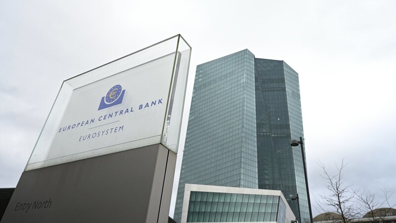 Eine Stele mit der Inschrift "European Central Bank Eurosystem" steht vor der Zentrale der Europäischen Zentralbank (EZB).