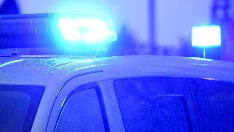 Blaulichter leuchten auf dem Dach eines Polizeifahrzeugs.