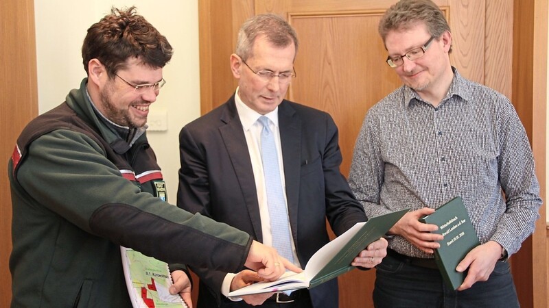 Forstrevierleiter Andreas Wolfrum übergibt das neue Forstgutachten an Bürgermeister Helmut Steininger und Richard Rebl.