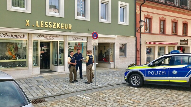 Polizeibeamte vor dem Schmuckgeschäft auf dem Stadtplatz, in dem am späten Freitagnachmittag ein Überfall stattgefunden hat.