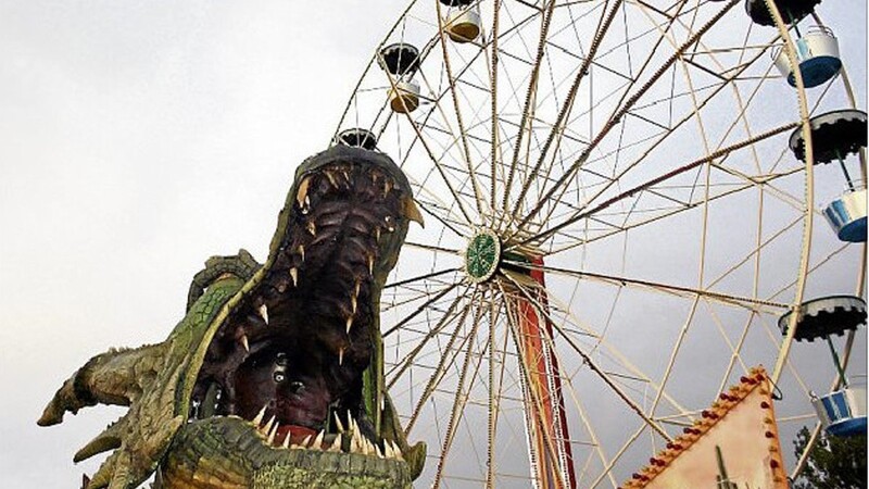 Drache "Tradinno" beim Einzug am Donnerstag auf der Festwiese, mit dem Riesenrad im Hintergrund.