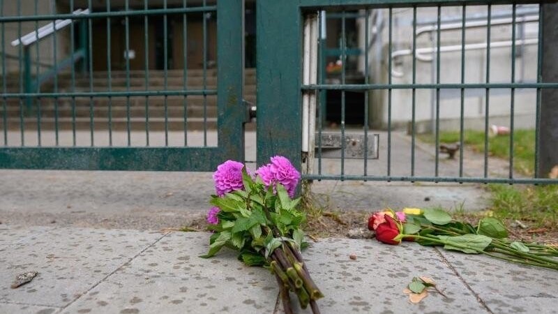 Passanten haben Blumen vor dem Eingangsbereich der Hamburger Synagoge abgelegt.