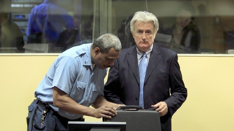 Der frühere bosnische Serbenführer Radovan Karadzic (R) steht am 03.03.2009 neben einem Justizbeamten in einem Gerichtssaal im Internationalen Gerichtshof in Den Haag. Karadzic gilt als einer der Hauptverantwortlichen für den Tod von etwa 10.000 Menschen während des Bosnienkrieges.