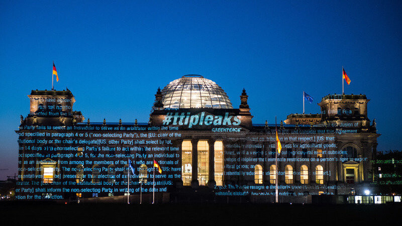 Aktivisten der Umweltorganisation Greenpeace projizieren am frühen Montagmorgen Teile des bisher geheimen Verhandlungstextes und den Schriftzug #ttipleaks auf die Fassade des Reichstagsgebäudes in Berlin
