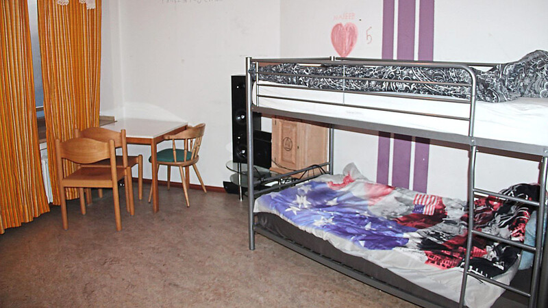 In diesem Zimmer leben zwei Jugendliche. Zur Ausstattung gehören ein Hochbett, ein Tisch, eine kleine Küchennische und ein kleines Bad.