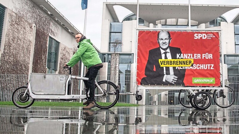 "Kanzler für Verbrennerschutz" steht auf einem ehemaligen SPD-Wahlplakat, das von der Umweltschutzgruppe Greenpeace umgestaltet worden war. Offenbar kursieren auch in Brüssel Autowitze über Scholz.