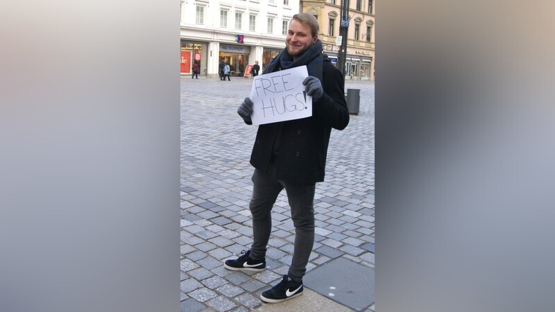Mit einem Schild, auf dem "Free Hugs" steht, ist Redakteur David Voltz auf dem Straubinger Stadtplatz unterwegs gewesen. (Fotos: Kerstin Bauer)