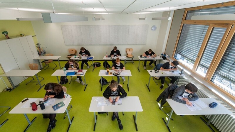 Abiturienten sitzen in einem Klassenzimmer.