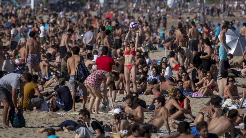 Als hätte die Pandemie nie in Spanien gewütet: Zahlreiche Menschen genießen in Barcelona das warme Wetter am Strand.