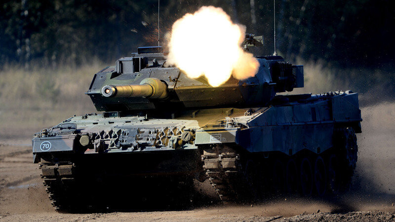 Ein Kampfpanzer Leopard 2 fährt am 02.10.2013 während der Bundeswehr-Übung Landoperationen in Munster (Niedersachsen) schießend durch das Gelände.