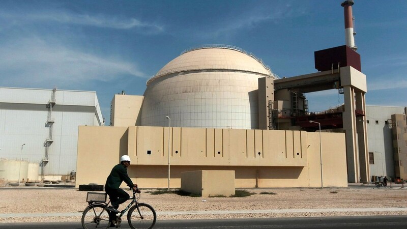 Ein Mann fährt mit dem Fahrrad an dem Reaktorgebäude des Kernkraftwerks Bushehr vorbei.