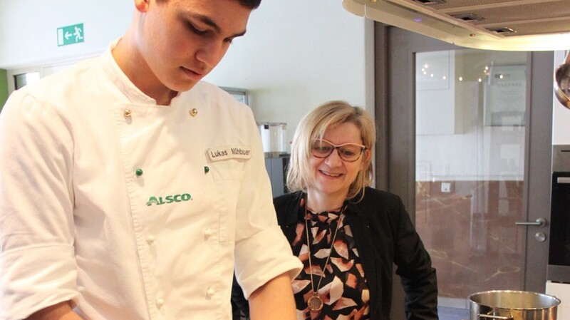 Lukas Mühlbauer bereitet in der Minikoch-Küche alles für die nächste Unterrichtsstunde der Miniköche vor. Manuela Heizler ist stolz auf den Werdegang ihres Schützlings.