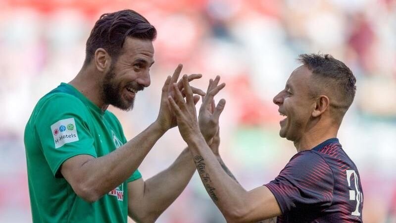 Werders Alt-Star Claudio Pizarro (l) und der damalige Bayer Rafinha begrüßen sich herzlich. Die beiden Südamerikaner liefen schon gemeinsam für die Bayern auf.