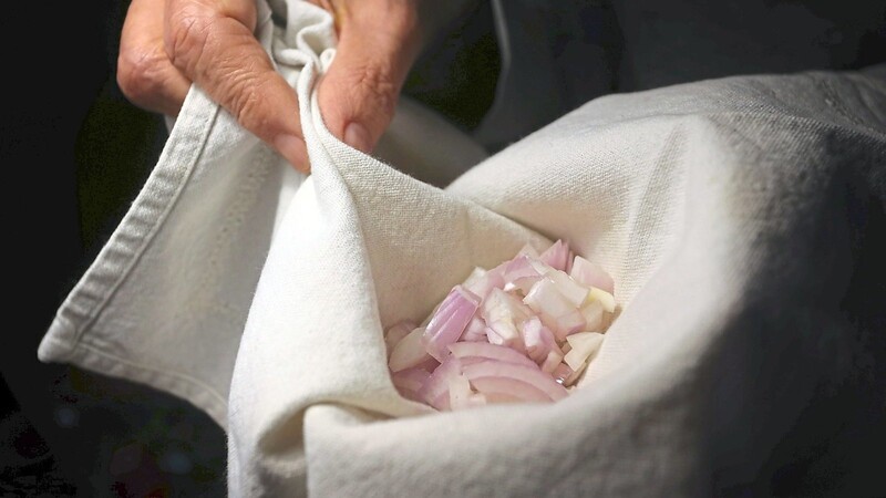 Ein Hausmittel, das bei Ohrenschmerzen helfen soll: Eine geschnittene Zwiebel wird in ein Tuch als Zwiebelsäckchen eingeschlagen.