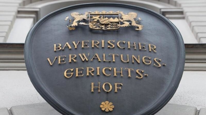 Ein Schild mit der Aufschrift "Bayerischer Verwaltungsgerichtshof" hängt an der Fassade des Gebäudes. Foto: picture alliance / Peter Kneffel/dpa/Archivbild