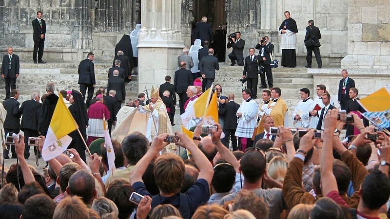 Die Menschen zücken ihre Digitalkameras. Jeder will von Papst Benedikt, der gleich in den Regensburger Dom einzieht, ein Erinnerungsfoto machen.