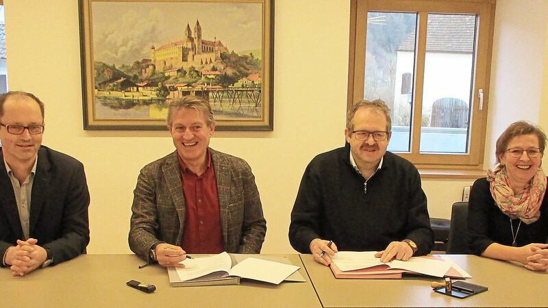Die Übernahme der Trägerschaft ist perfekt: Geschäftsführer Roland Böck und Pfarrer Alois Hammerer unterzeichnen in Anwesenheit von Kinderhausleiterin Monika Kulzer den Vertrag.
