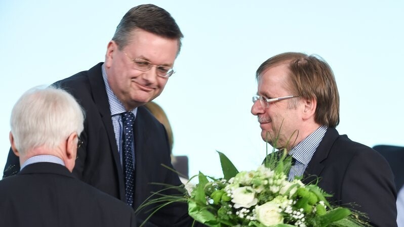 Der designierte DFB-Präsident Reinhard Grindel (M) überreicht am 15.04.2016 beim Außerordentlichen DFB-Bundestag in Frankfurt am Main (Hessen) Blumen an die beiden DFB-Vizepräsidenten Reinhard Rauball (l) und Rainer Koch.