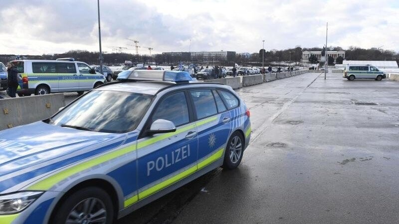 Ein Polizeiauto und Teilnehmer eines Autokorso sind auf der Theresienwiese zu sehen.